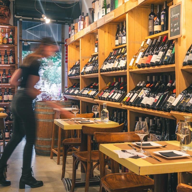 Vue intérieure de la cave avec étagères de bouteilles, tables et espace de dégustation