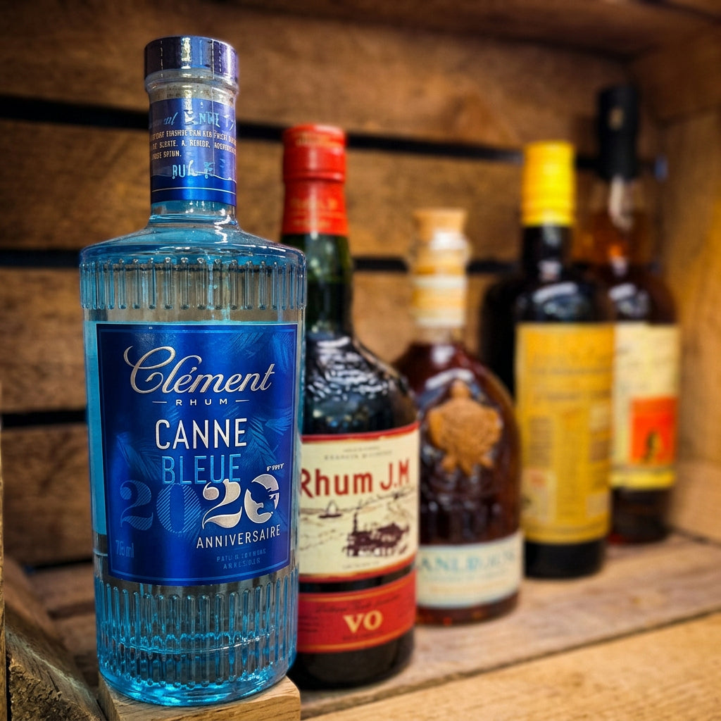 Bouteille de rhum Clément Canne Bleue au premier plan, devant une sélection de bouteilles de rhum.