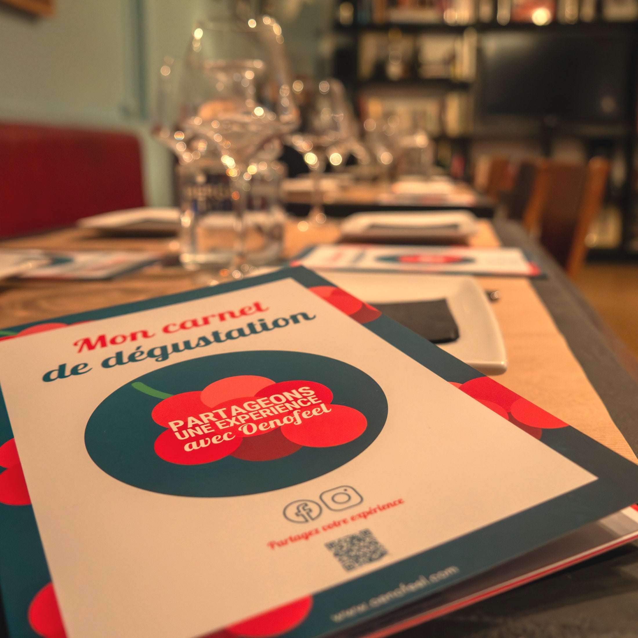 Bon cadeau pour une expérience de dégustation Oenofeel posé sur une table de la cave